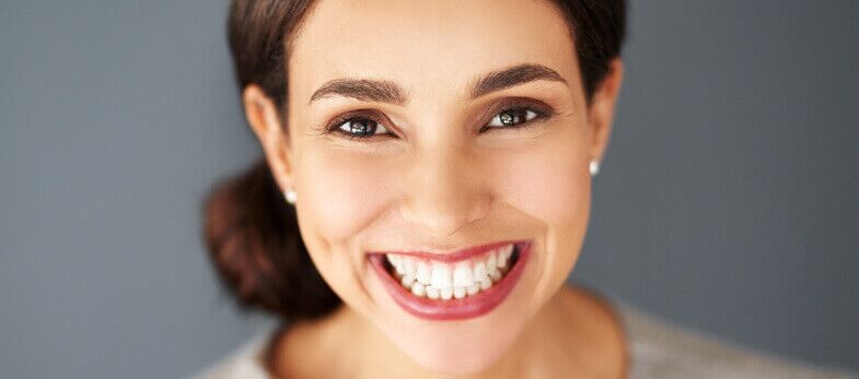 Teeth whitening Wimbledon - A woman with a radiant, bright smile, showcasing the results of teeth whitening treatment at Ridgway Dental, a dental clinic in Wimbledon. Her perfectly aligned, white teeth are prominently displayed, emphasizing the effectiveness of the dental procedure. The background is simple, ensuring the focus remains on her dazzling smile. This image highlights the professional teeth whitening services provided by Ridgway Dental, aiming to enhance dental aesthetics and boost patient confidence.